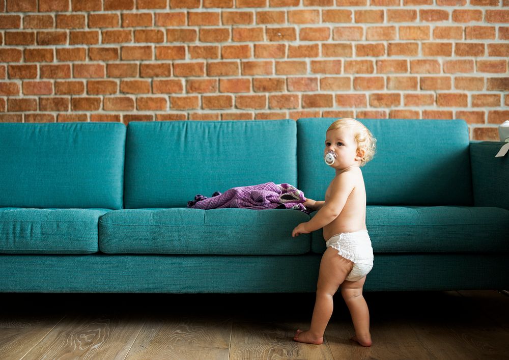 Baby standing by the couch