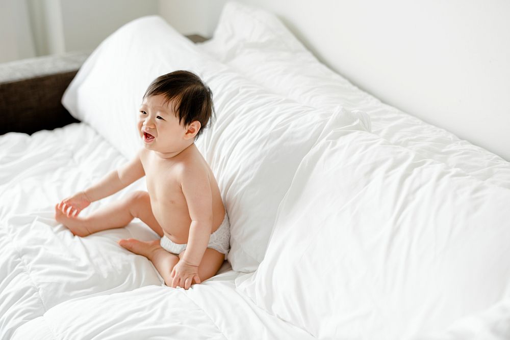Cute Asian baby alone in bed