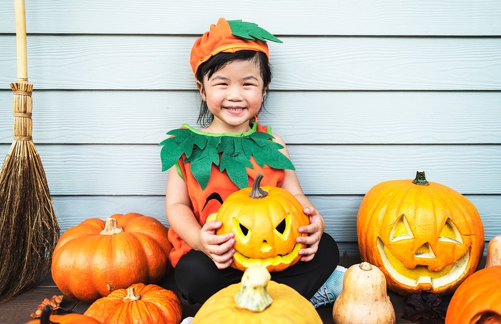 Little kid with Halloween pumpkin