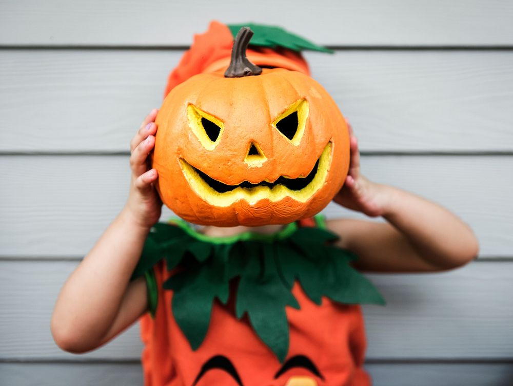 Little kid with Halloween pumpkin