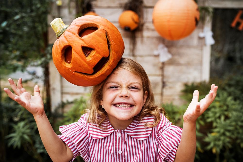 Young playful girl with her Halloween jack-o'-lantern