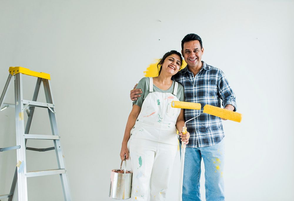 Couple renovating their new house by painting the walls