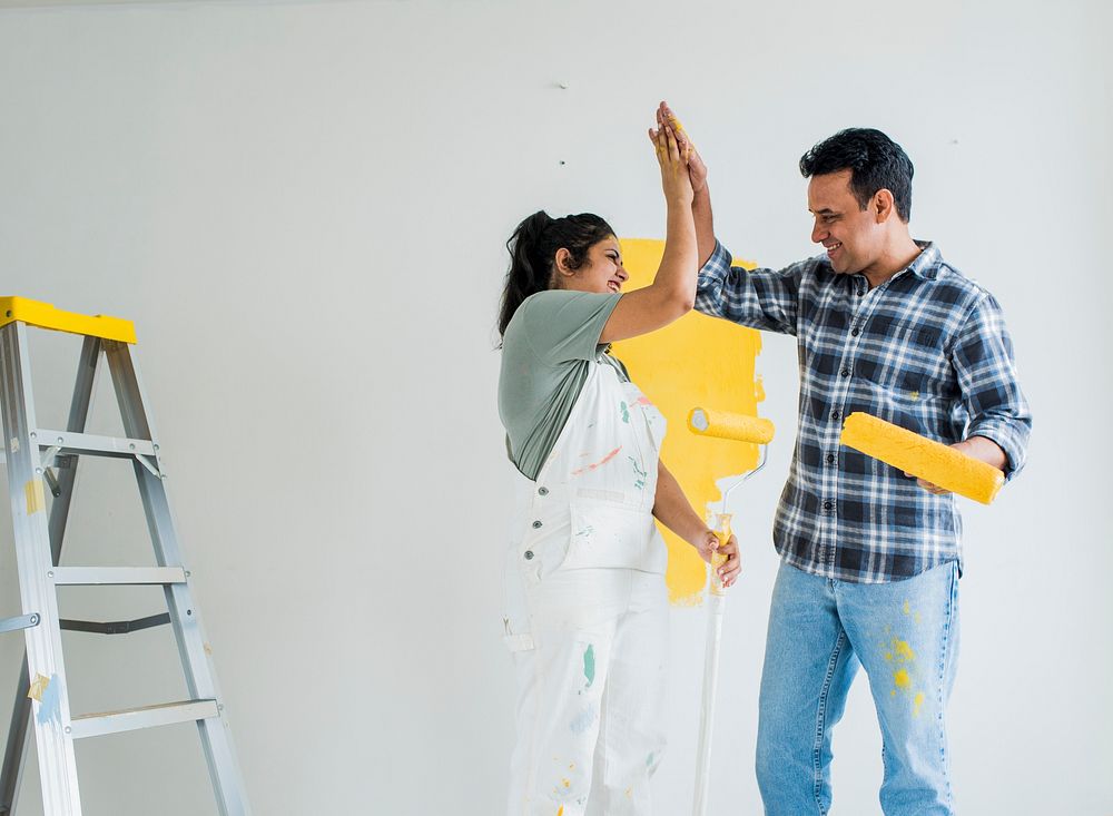Couple giving a high five while renovating their new house