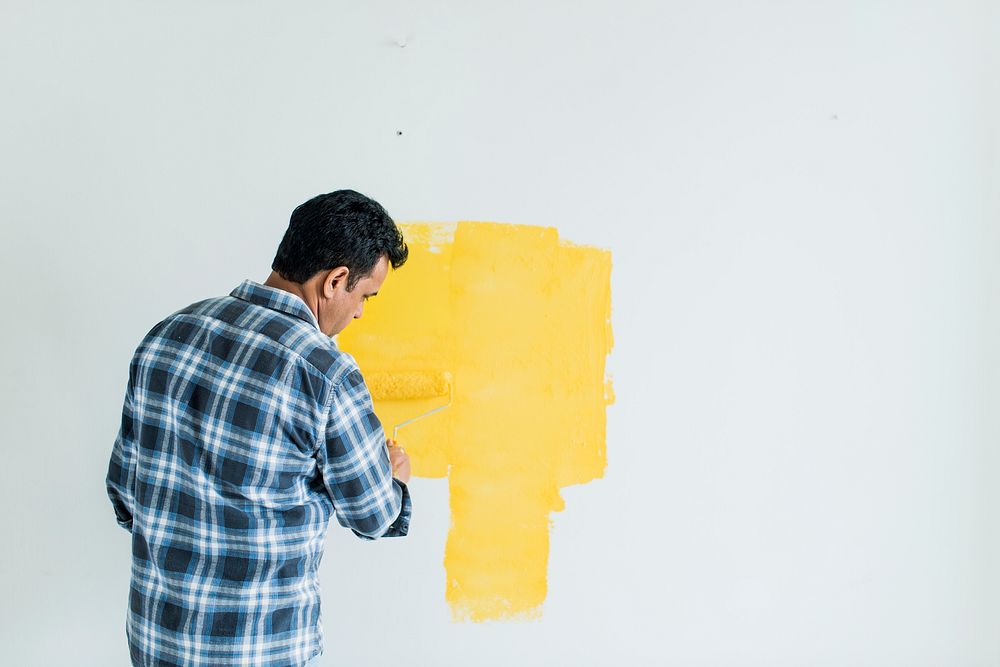 Man painting the walls yellow