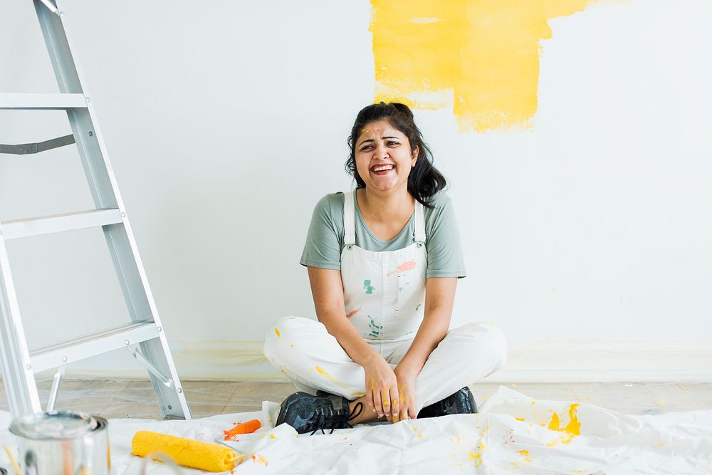 Woman painting her walls yellow