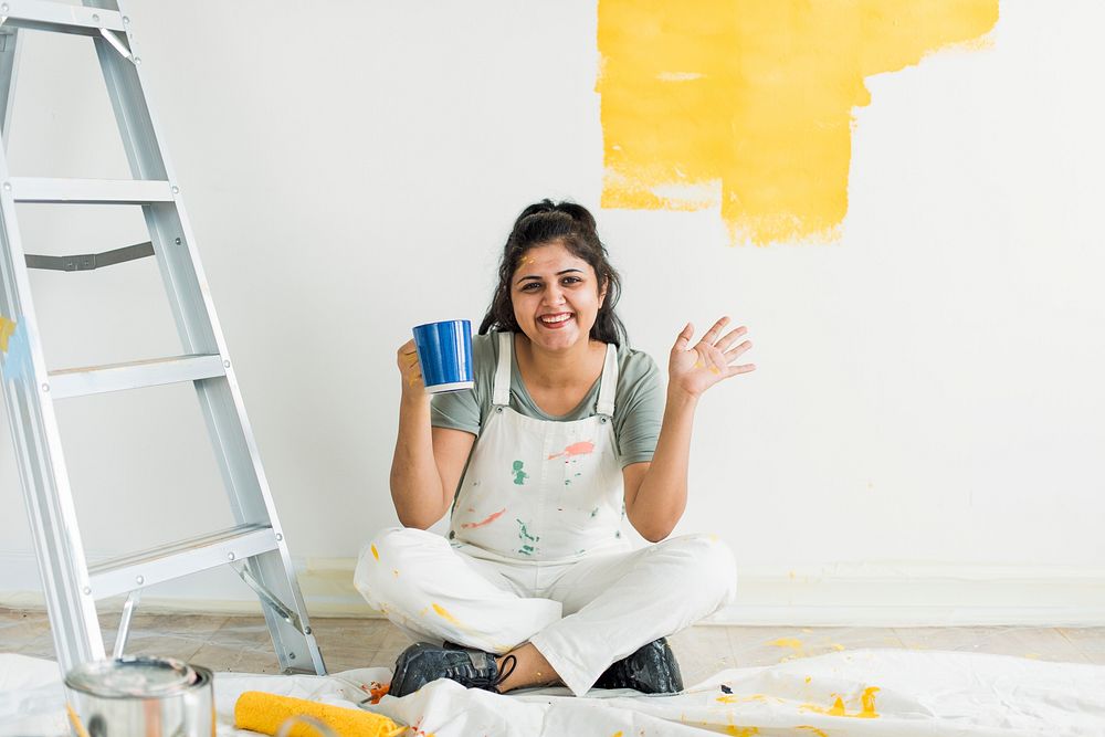 Woman painting her walls yellow