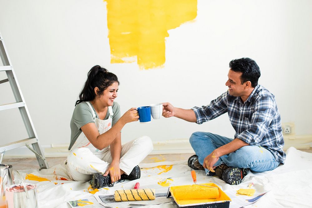 Couple taking a break from painting the walls