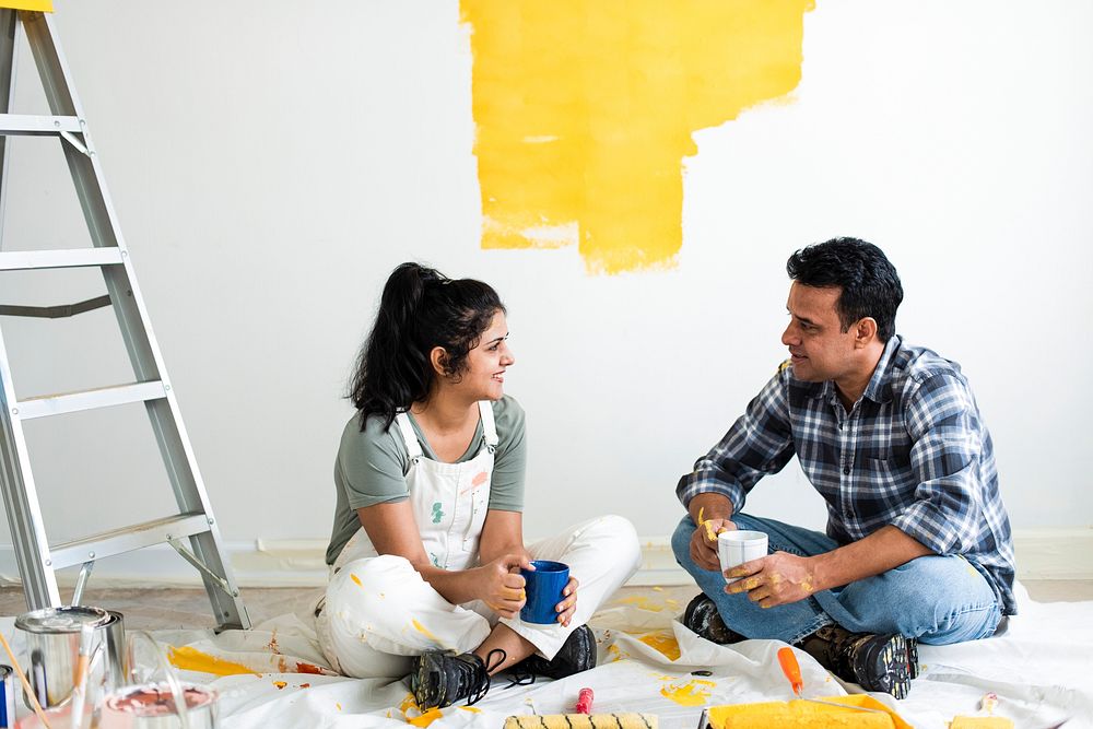 Couple taking a break from painting the walls