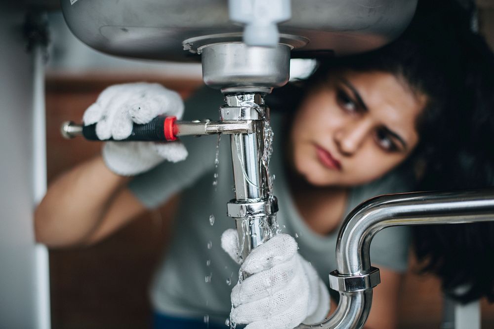 Woman fixing a kitchen sink