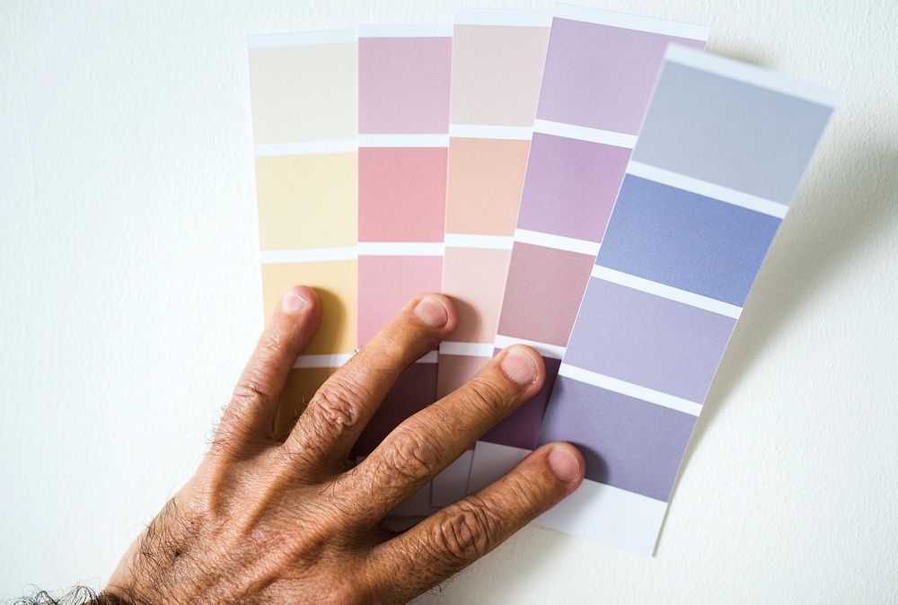 Man choosing wall color by choosing from a color swatch
