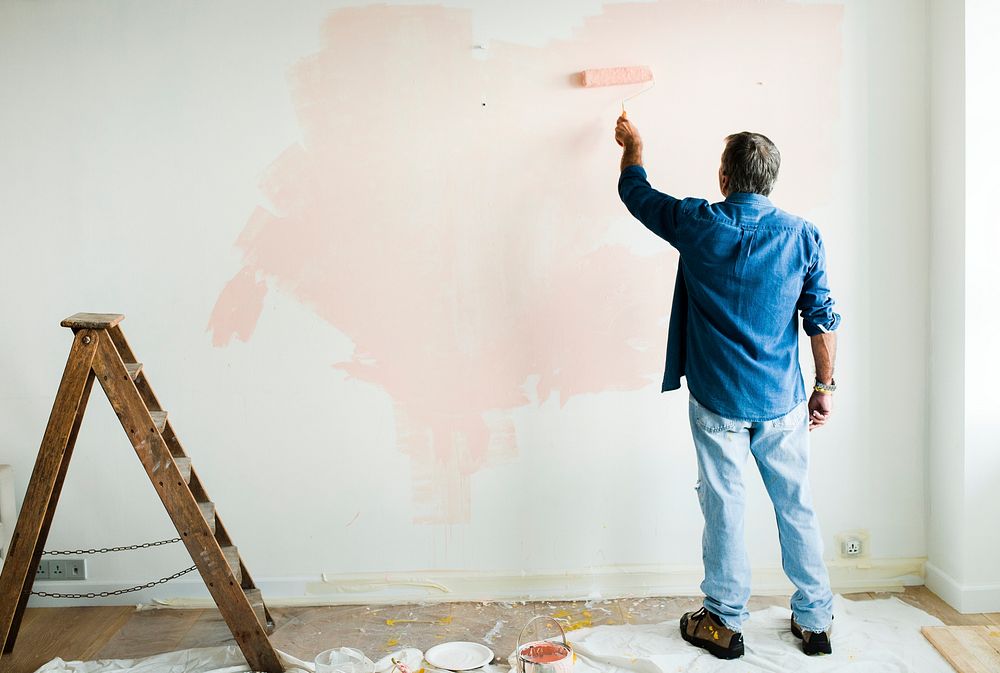Man painting the walls pink