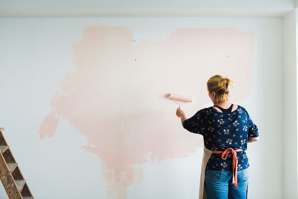 Woman painting the walls pink