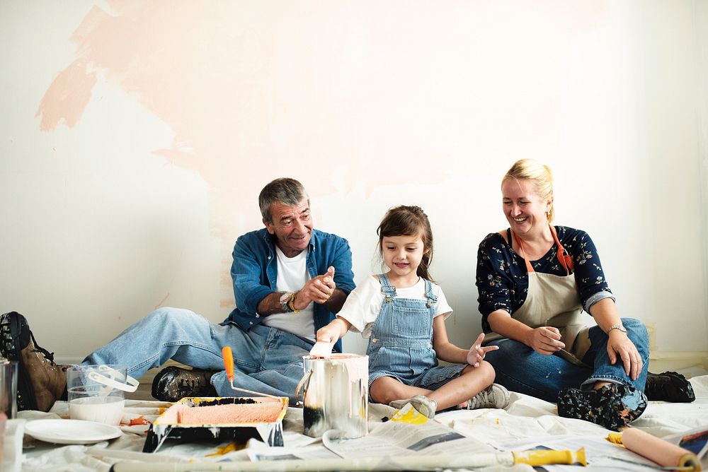 Cheerful family relaxing after painting the room