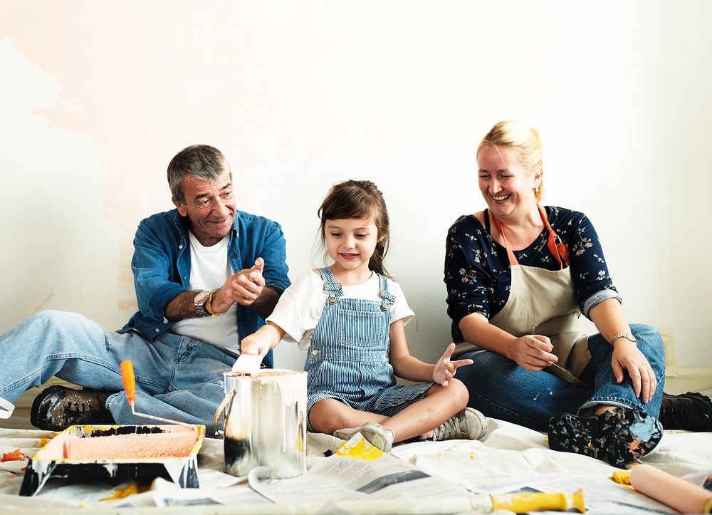 Cheerful family relaxing after painting the room