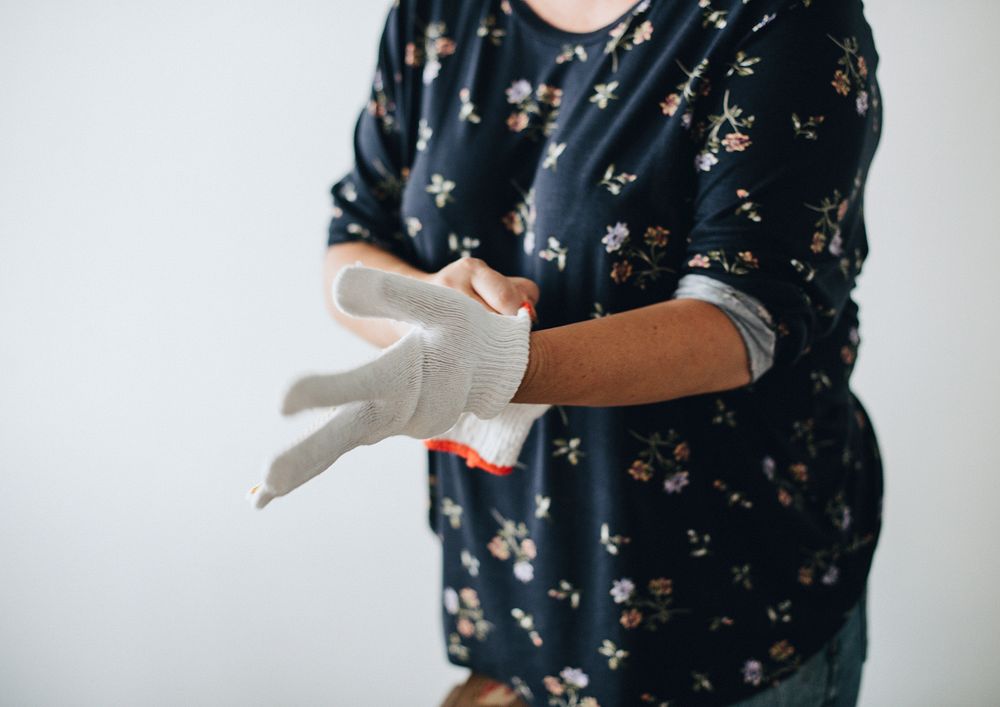 Woman putting on protective gloves