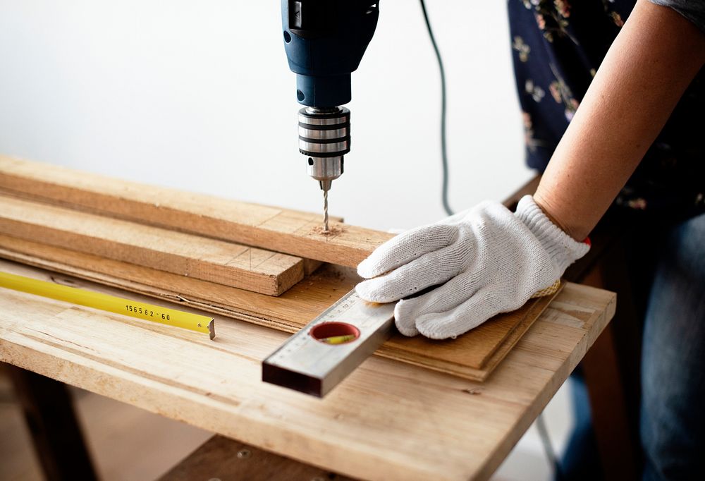 Woman drilling into a wooden plank