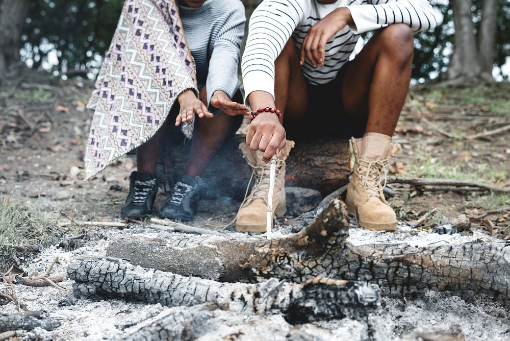 Couple sitting by the bonfire ashes