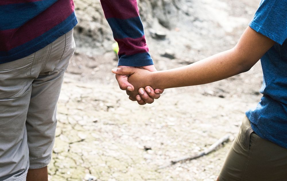 Cheerful couple holding hands on a trek
