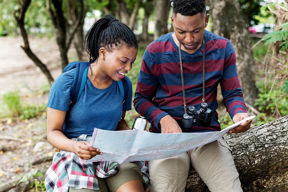 Trekking couple using a map in a forest