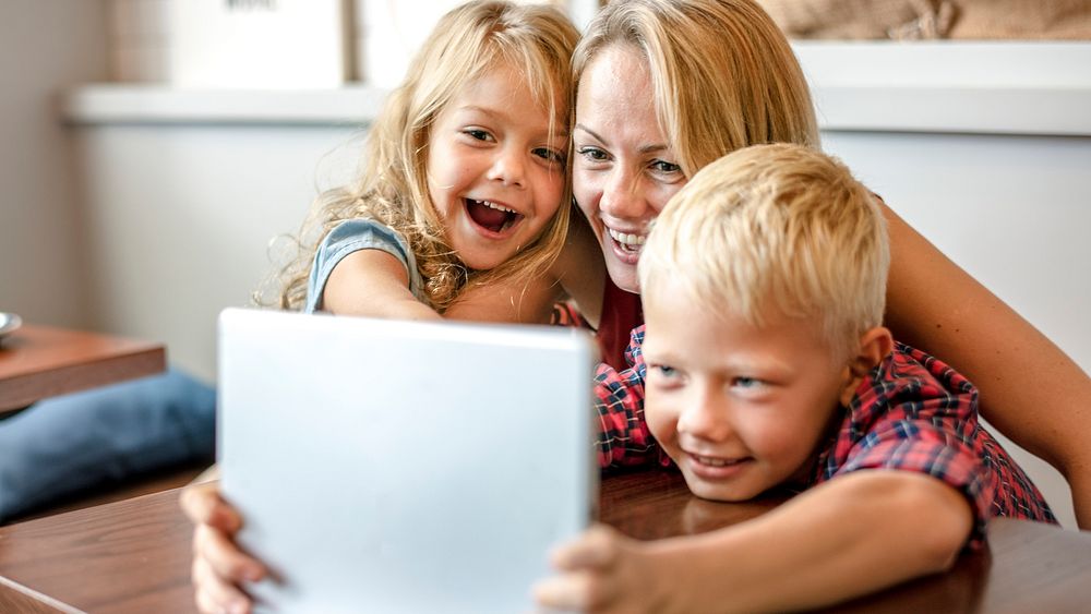 Blonde mom and kids making a video call on a tablet