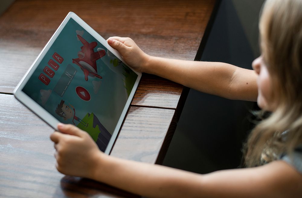 Little girl playing a game on a digital tablet