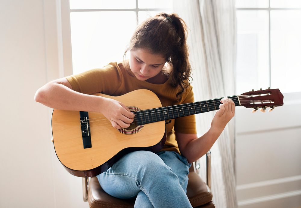 Teen girl playing the guitar