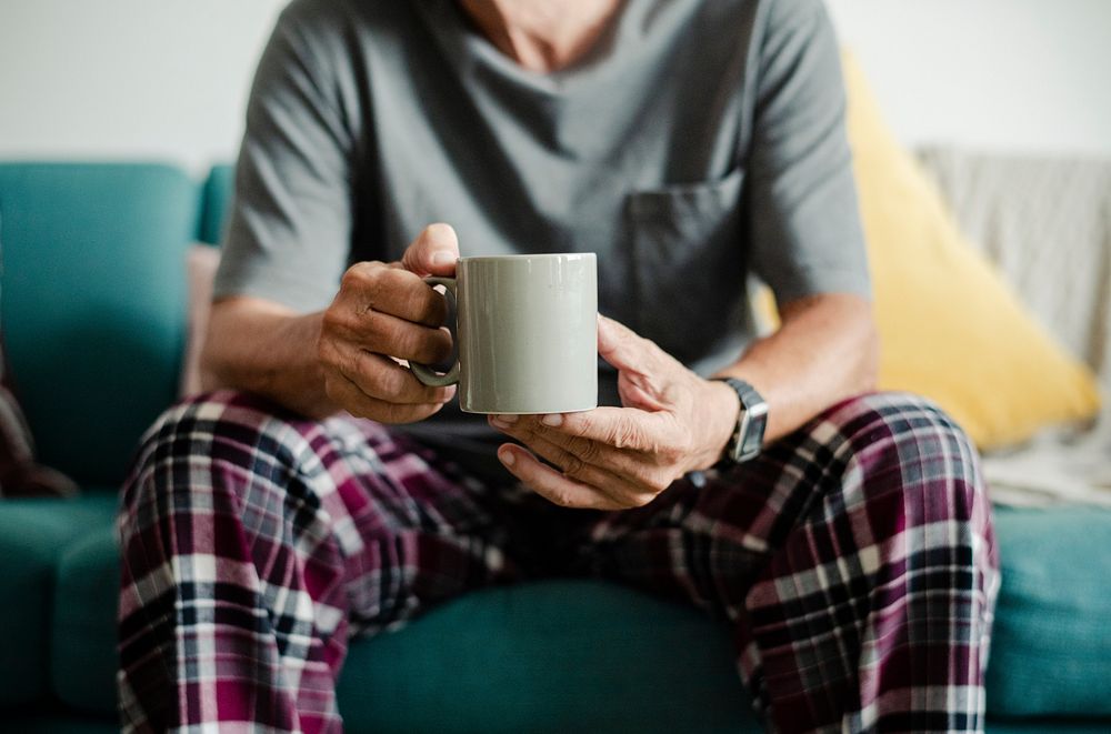 Man having his morning coffee on the sofa