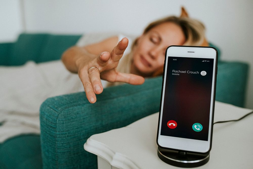 Drowsy woman reaching for her phone