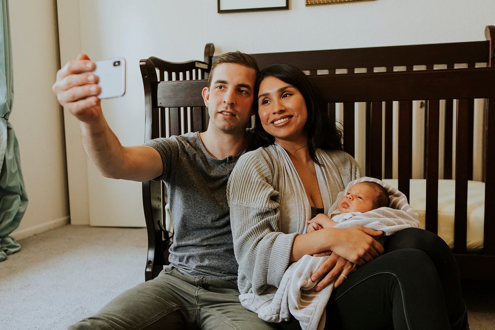 Young couple taking a family selfie