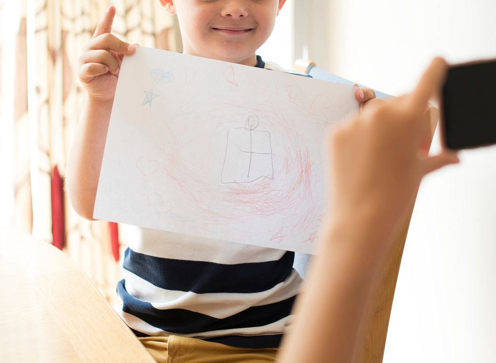 Little boy showing off his drawing
