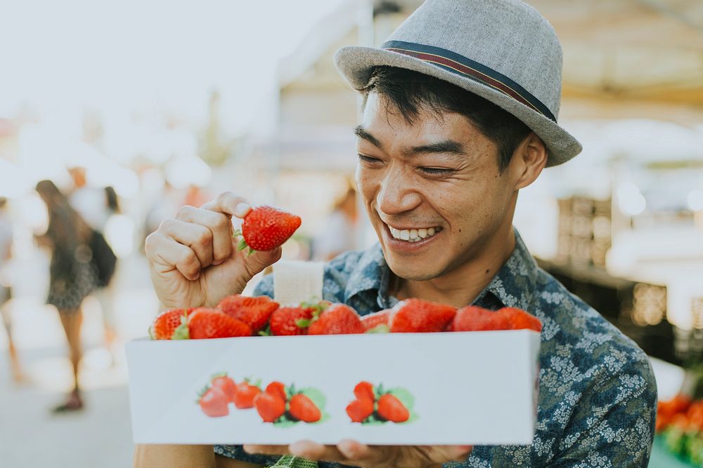 Man buying strawberries at a farmers market