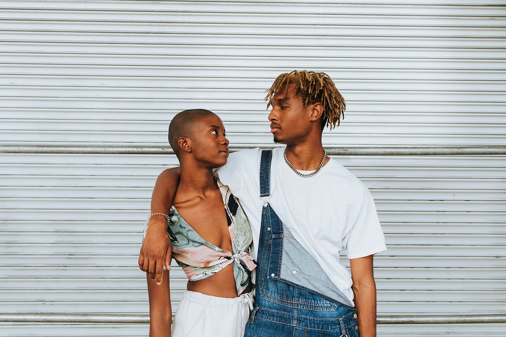 African american couple posing by a wall