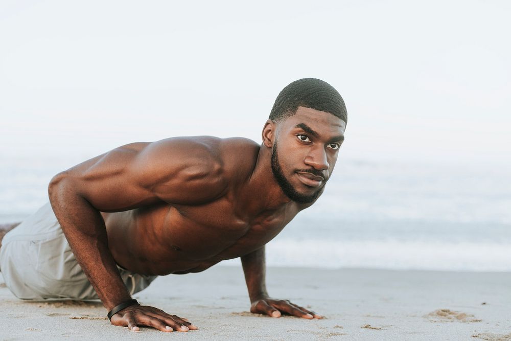 Fit man doing pushups in the sand