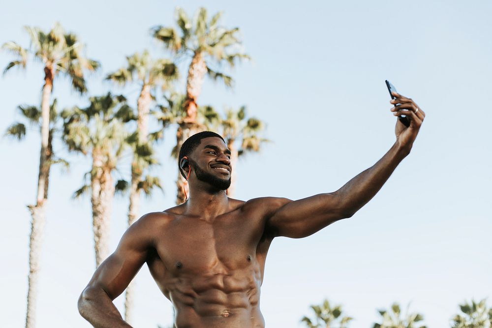 Fit man taking a selfie at the beach