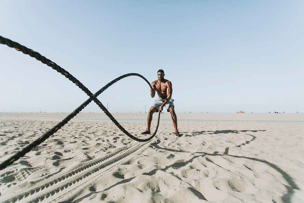 Fit man working out with battle ropes