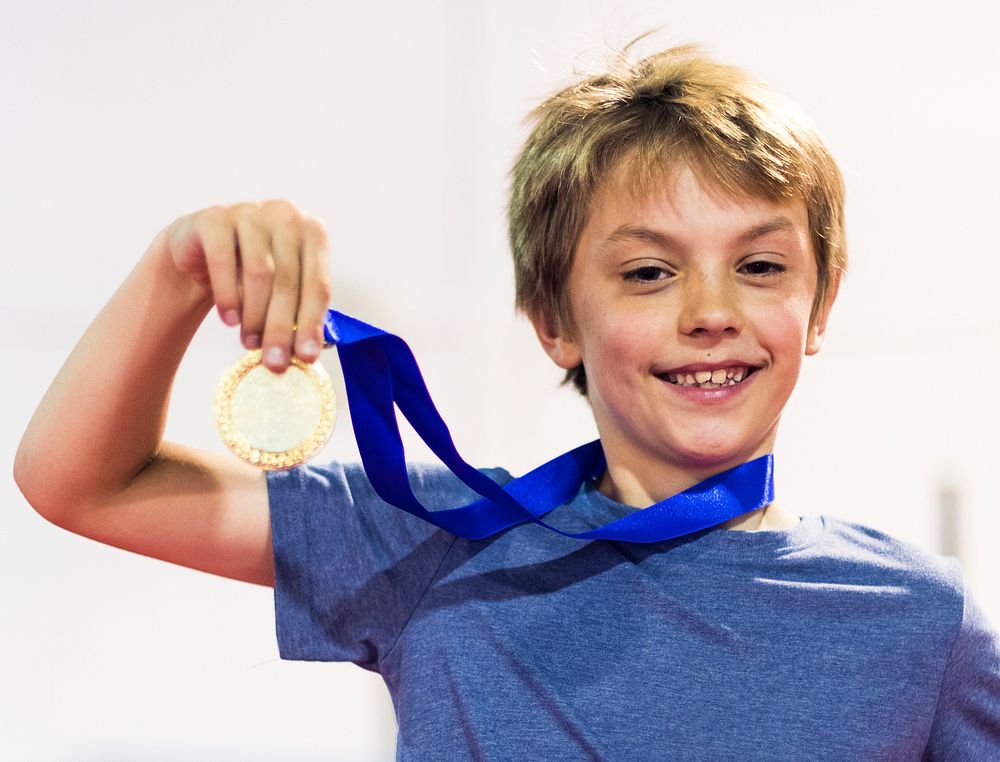 Young gymnast showing his golden medal