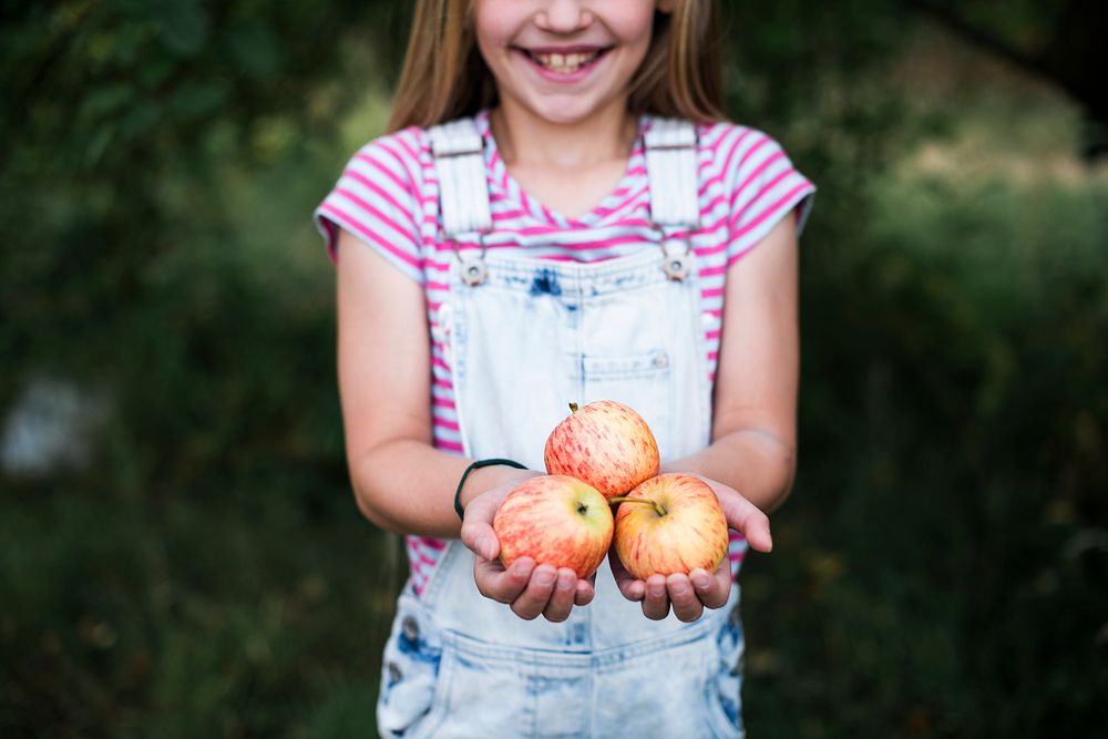 Young girl holding apples in her hands