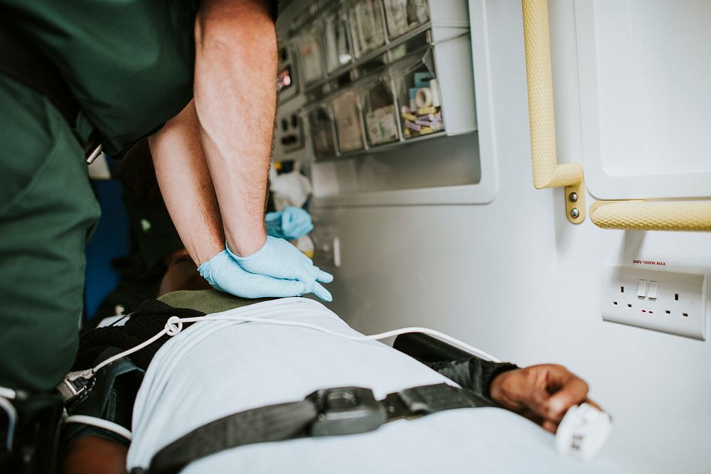 Paramedic resuscitating a patient in an ambulance