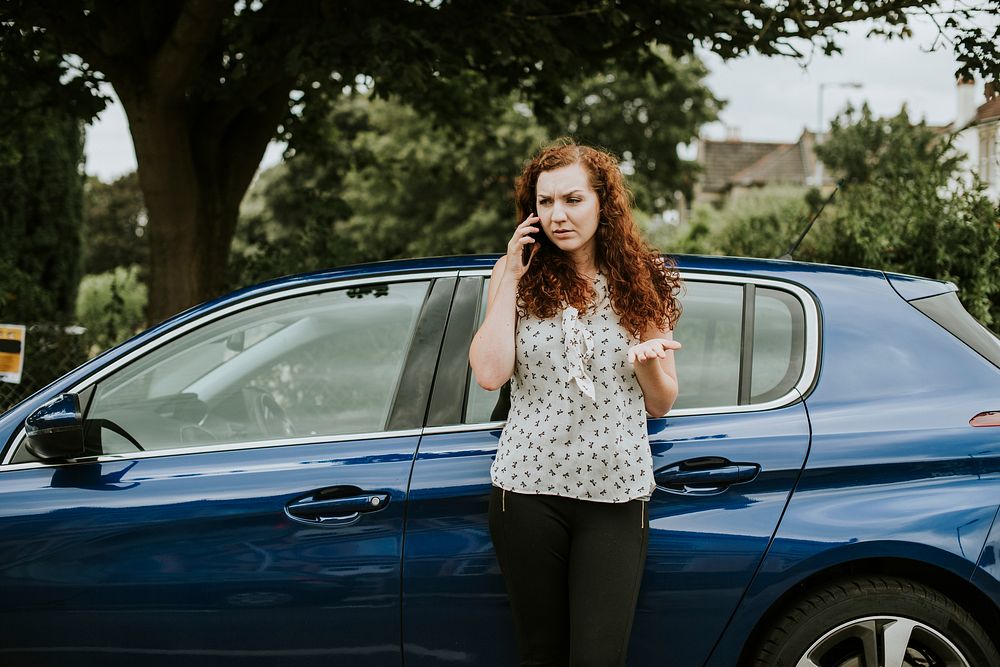 Woman standing by her car talking on the phone