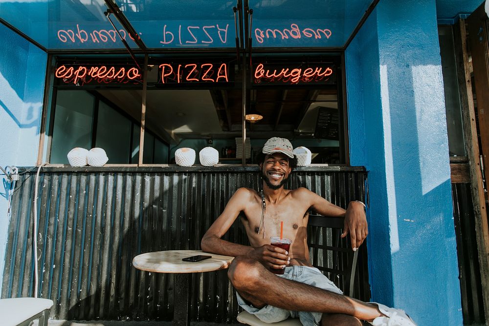 Shirtless man sitting at a cafe