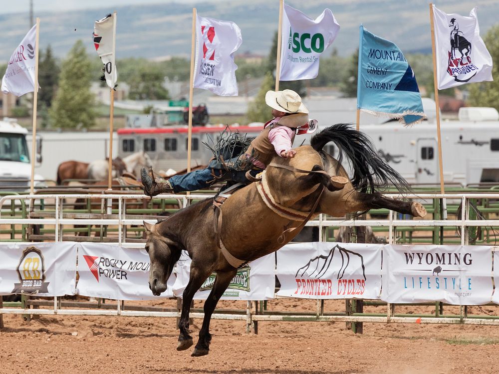 A cowpoke doesn't have much time left aboard this bucking bronco at a large outdoor rodeo that's a feature of the annual (on…