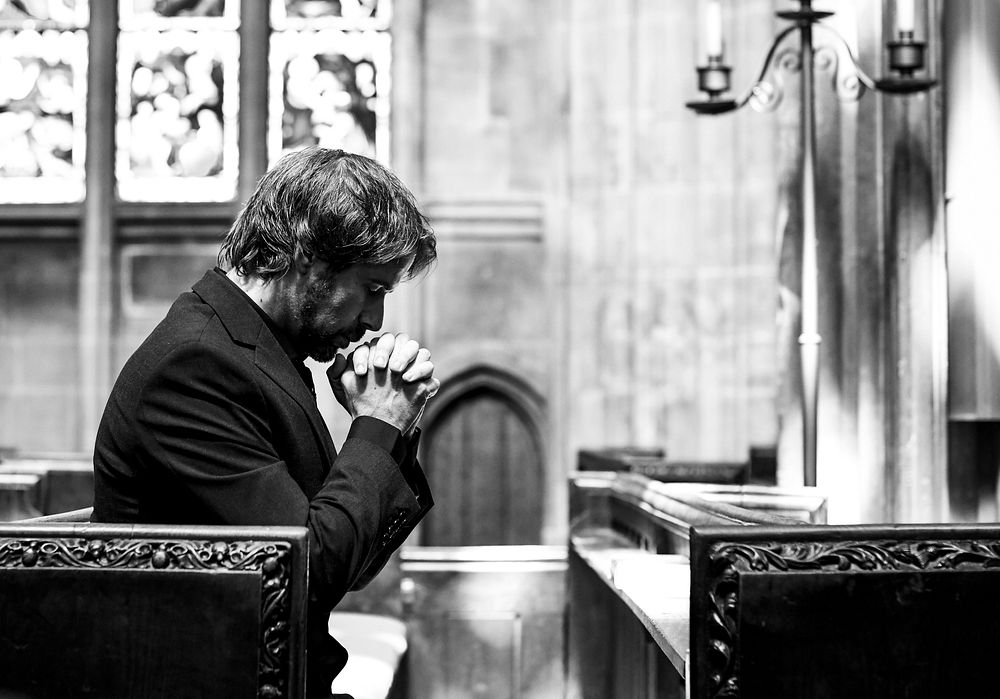 Lonely Christian man praying in the church