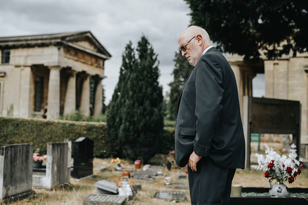 Lonely widower mourning at the graveyard