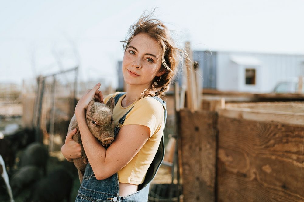 Young volunteer with a piglet, The Sanctuary at Soledad, Mojave