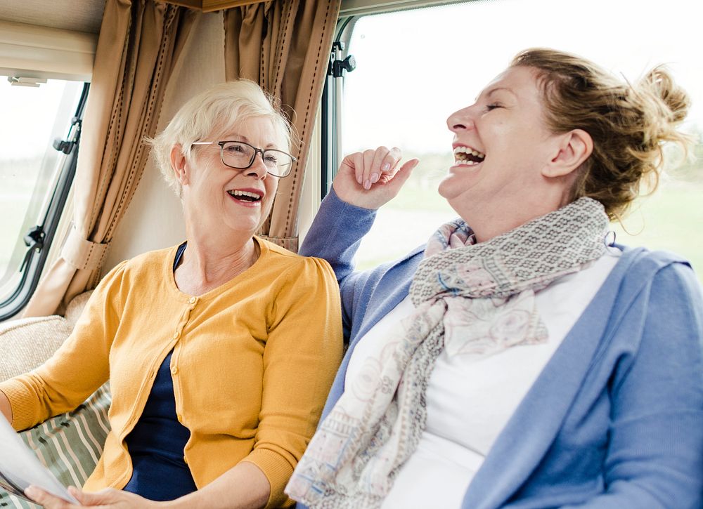Cheerful elderly women discussing the newspaper