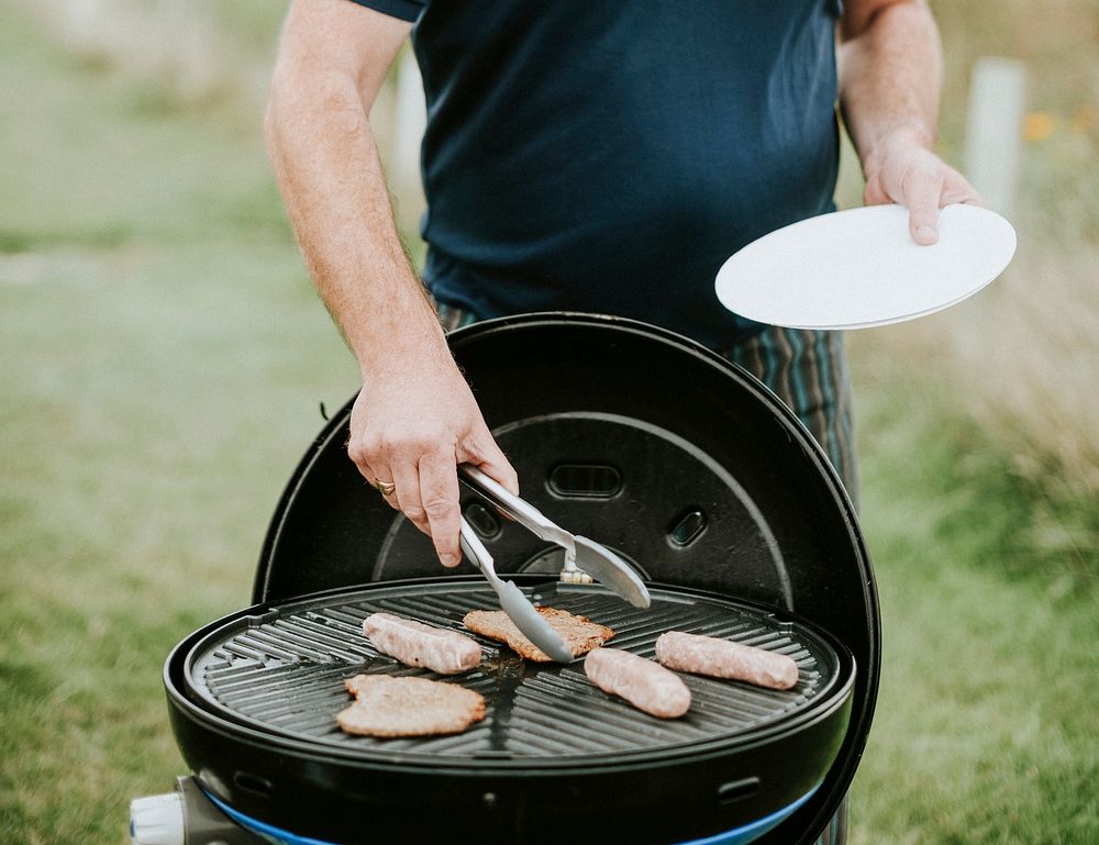 Man grilling meat sausages outdoor