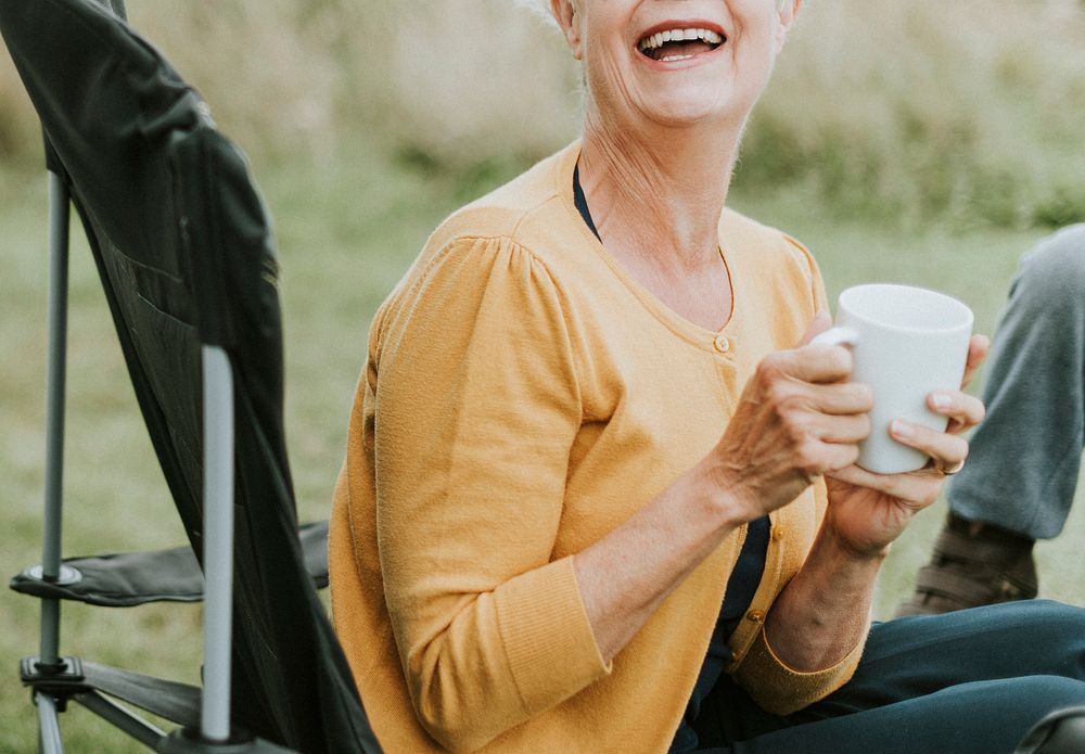 Cheerful senior woman enjoying a mug of coffee