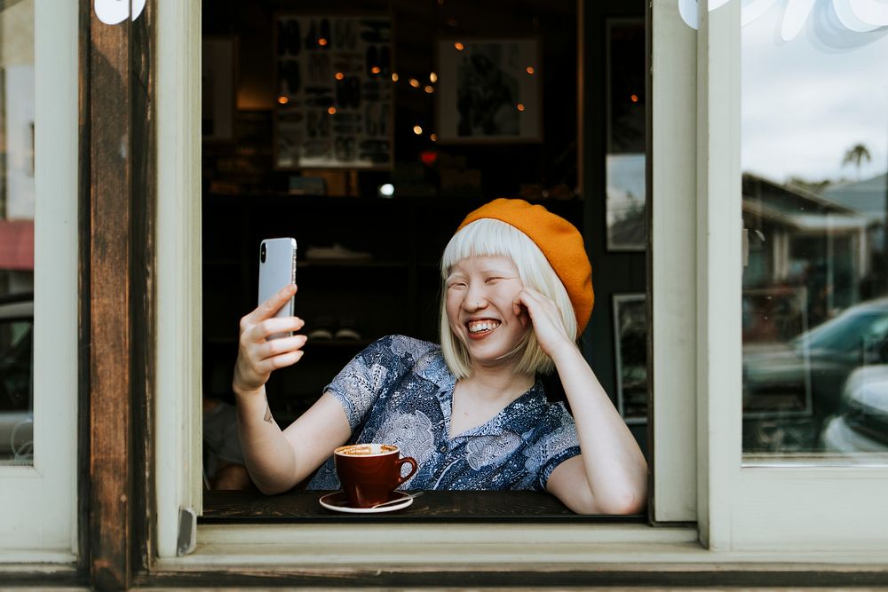 Cure traveler having a video call at a cafe