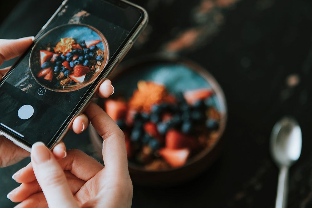 Blogger capturing a healthy breakfast photo to post online