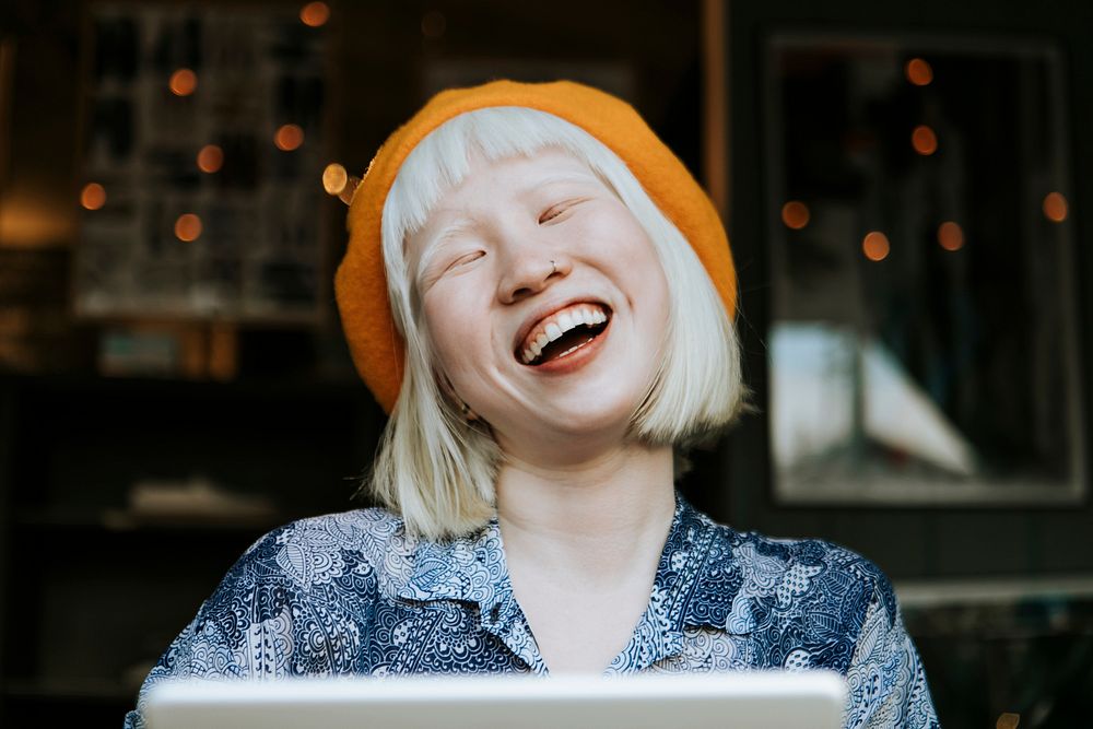 Cut albino girl talking to her friends through a digital tablet